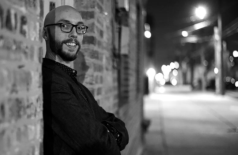 Dan Tertell wide shot leaning against brick wall at night in downtown LaGrange, Illinois