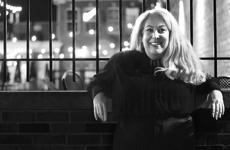 Michelle Crowe standing against the fence in downtown LaGrange, Illinois