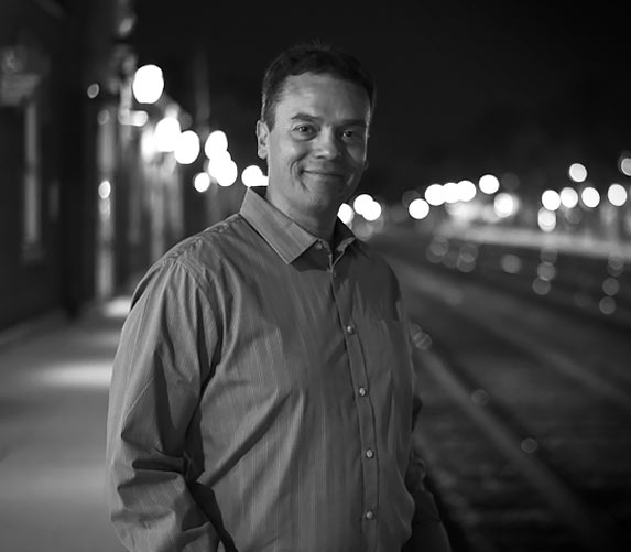 Steve Kostal in front of railroad tracks.