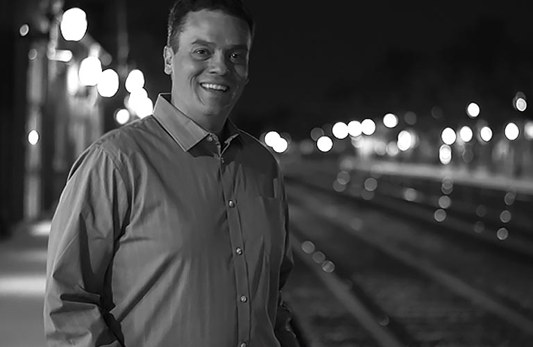 Steve Kostal in front of railroad tracks.